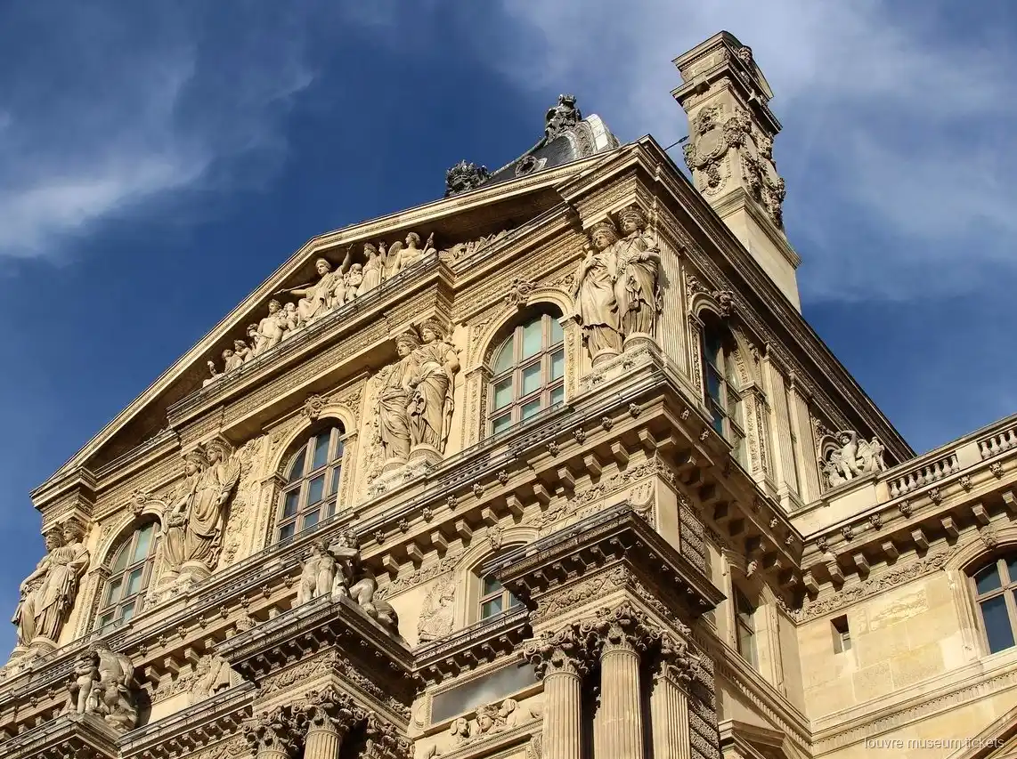 Facciata scolpita del Louvre con statue, frontone e colonne sotto il cielo blu, vista con biglietti Museo del Louvre