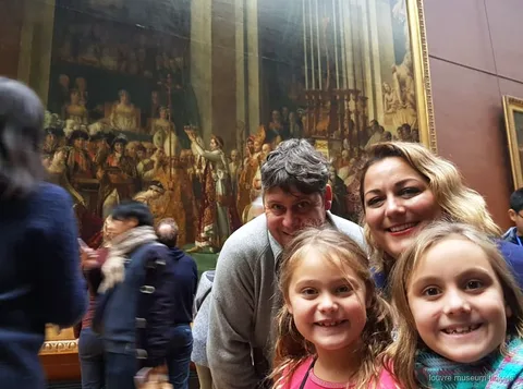 Private family tour guide showing Louvre Museum masterpieces to children and parents