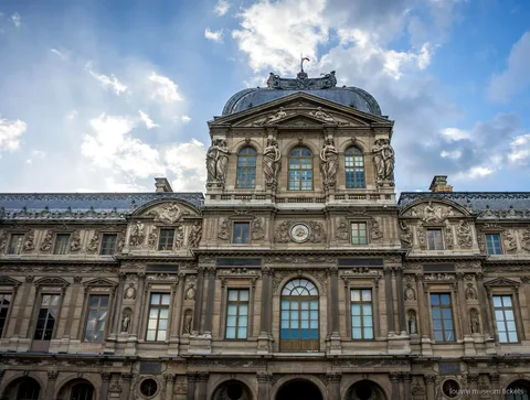 青空の下に建つドームと彫像で飾られたルーブル美術館の時計の館、ルーブル美術館チケットで訪れる外観