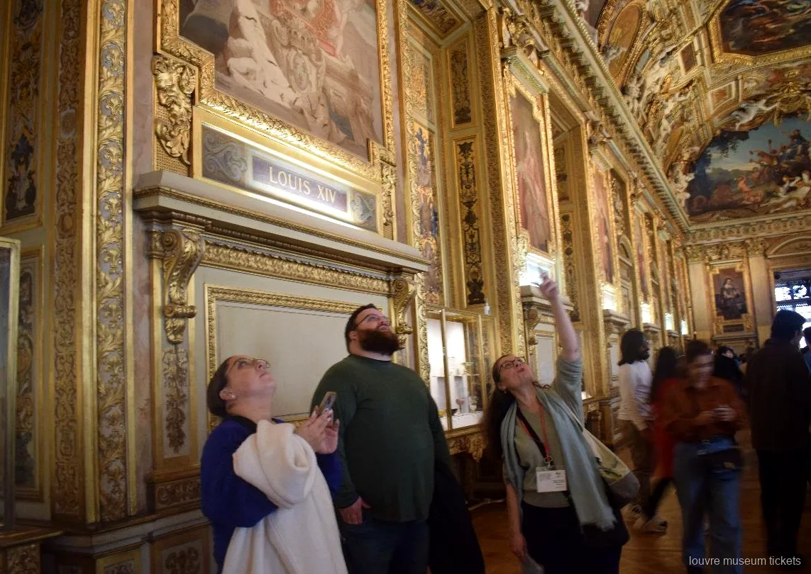 Petit groupe admirant le plafond peint et doré de la galerie d'Apollon, visite avec billets musée du Louvre